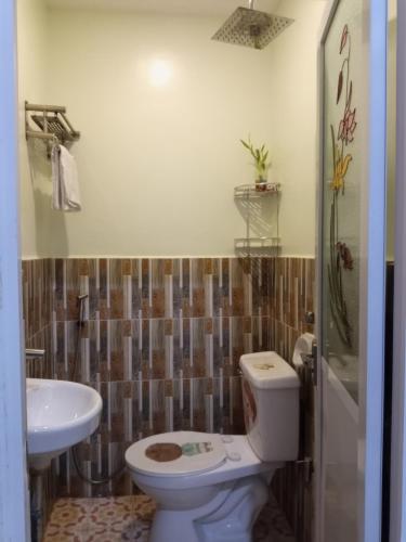 a bathroom with a toilet and a sink at golden anchor lodge in Coron