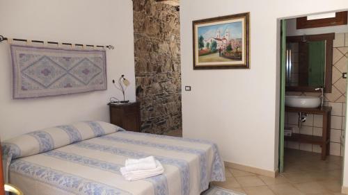 1 dormitorio con 1 cama y una pintura en la pared en Casa Camilla Sardegna en San Vito