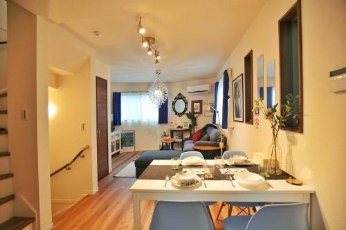 uma sala de jantar e sala de estar com mesa e cadeiras em SG5371 Visit Shibuya Crossing! Walking distance to a single family home for 8 people, private parking , downstairs supermarket food Shibuya em Tóquio