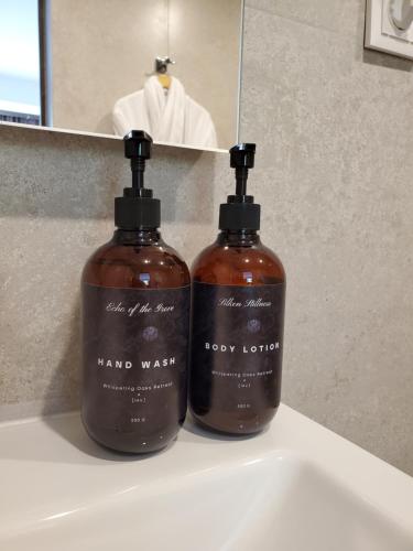 two bottles of hand soap sitting on a bathroom sink at The Whispering Oaks Retreat in Vahagnadzor