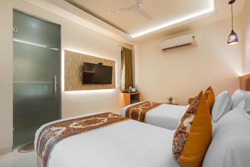 a hotel room with two beds and a tv at Hotel Comfort Court in Amritsar