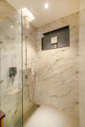 a bathroom with a shower with a glass door at Hotel Comfort Court in Amritsar