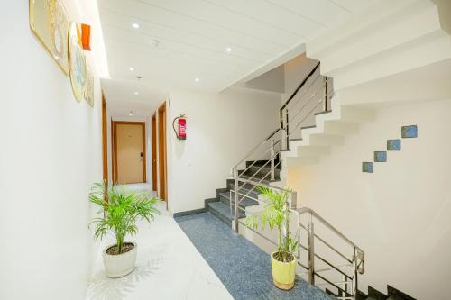 a staircase in a building with two potted plants at Hotel Comfort Court in Amritsar