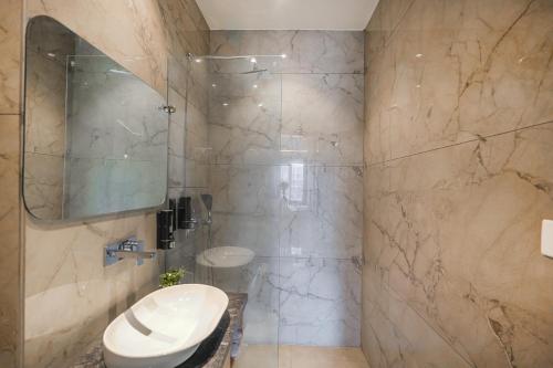 a bathroom with a sink and a toilet and a mirror at Hotel Comfort Court in Amritsar