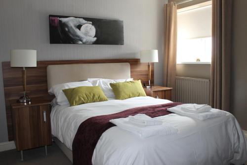 a bedroom with a large bed with towels on it at The Fairways in Rotherham