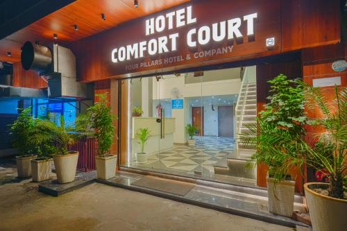 a hotel concert court with potted plants in front of it at Hotel Comfort Court in Amritsar