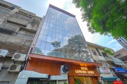 a tall building with a glass facade on a street at Hotel Comfort Court in Amritsar