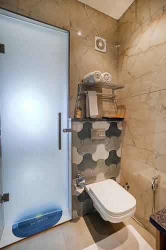 a bathroom with a toilet and a glass door at Hotel Comfort Court in Amritsar