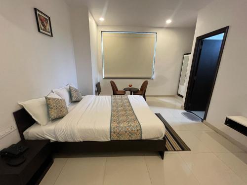 Un dormitorio con una cama y una mesa y sillas. en Hotel O Aabha Residency, en Jaipur
