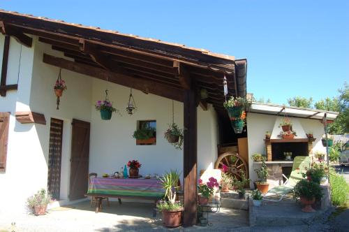 Chambres d'hôtes Esponde Marie-Jeanne في Saint-Jean-le-Vieux: منزل به مقاعد ونباتات خزفية