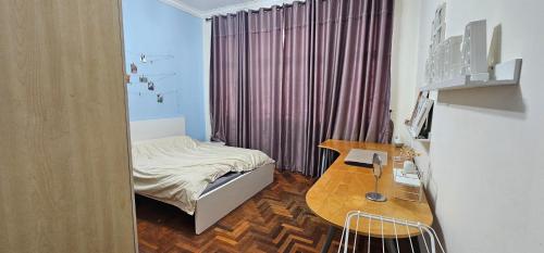 a small bedroom with a bed and a desk at CalOlie Villa in Shah Alam