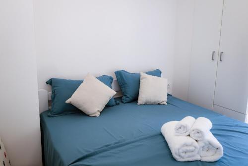 a blue bed with towels on top of it at Twins in Tivat