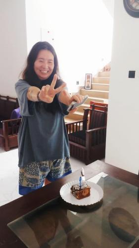 a woman giving the peace sign with a piece of cake at Blueray Villa in Unawatuna
