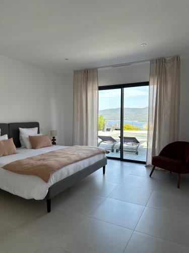 a bedroom with a bed and a sliding glass door at Torriciola location Casa Rocca in Propriano