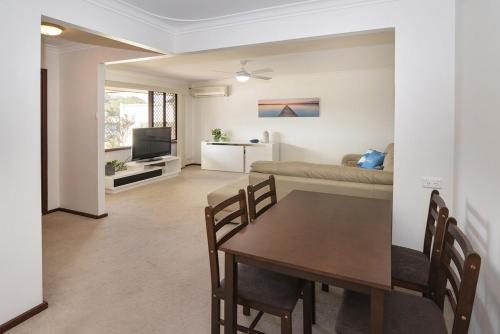 a dining room and living room with a table and a couch at A Shore Thing- Located opposite Busselton Foreshore! in Busselton