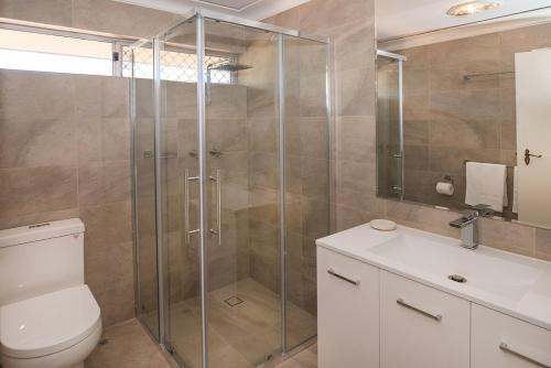 a bathroom with a shower and a toilet and a sink at A Shore Thing- Located opposite Busselton Foreshore! in Busselton