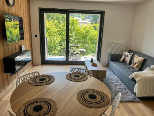 Una sala de estar con una mesa de madera y un sofá. en Luxurious flat at St Gervais, en Saint-Gervais-les-Bains