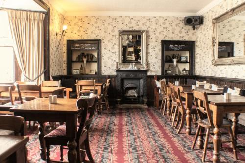 a restaurant with tables and chairs and a fireplace at The Royal Oak Hotel in Helmsley