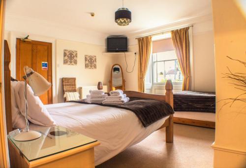 a bedroom with a bed with towels on it at The Royal Oak Hotel in Helmsley