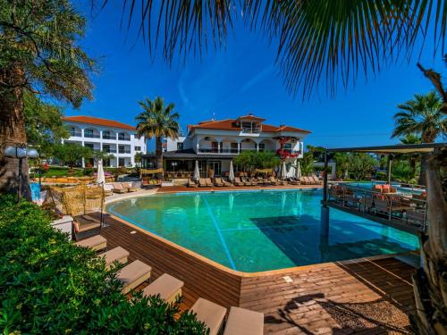 ein Pool mit Stühlen und ein Resort in der Unterkunft Flegra Palace in Pefkohori