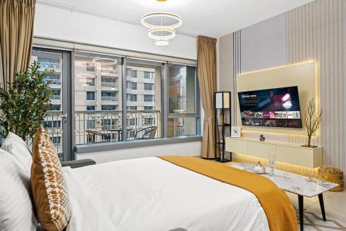 a bedroom with a large bed and a tv at White House With Burj Views, Free Parking in Dubai