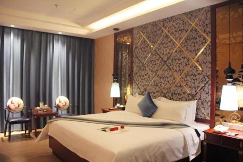 a hotel room with a large bed and a window at Shenzhen Kai Long International Hotel in Shenzhen