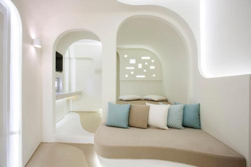 una camera con pareti bianche e un divano con cuscini di Andronikos Santorini a Imerovigli