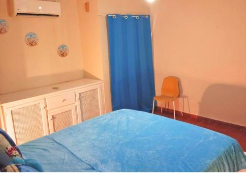 a bedroom with a bed and a blue curtain at Beachfront Serenity Villa with Pool, AC, 1 min from the the beach, Jacuzzi, Wifi in Sabana Grande de Palenque