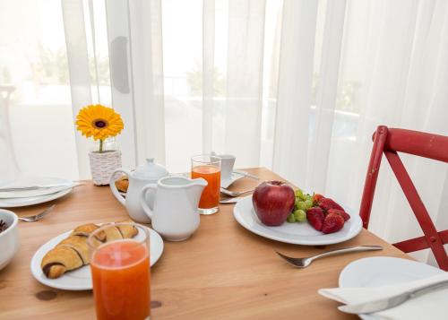 a wooden table with plates of fruit and juice at BB De Rohan in Żebbuġ