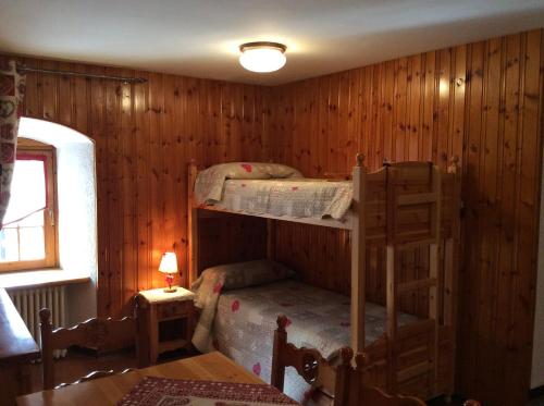 two bunk beds in a room with wooden walls at B&B La Vieille Meison de Pappa in Aosta