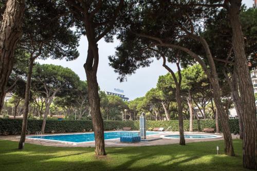 ブラナスにあるApartamentos Blanes-Condal Costa Bravaの木々が茂る公園内のスイミングプール