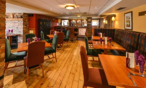 a restaurant with wooden tables and chairs and a bar at Cromore Halt in Portstewart