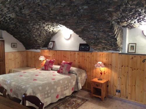 a bedroom with a bed and a stone ceiling at B&B La Vieille Meison de Pappa in Aosta