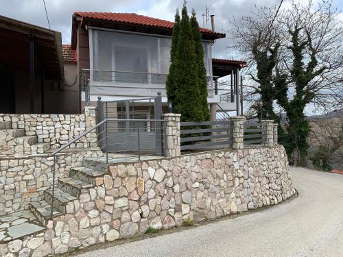 a house with a stone wall and a fence at Konstantakos Michail 