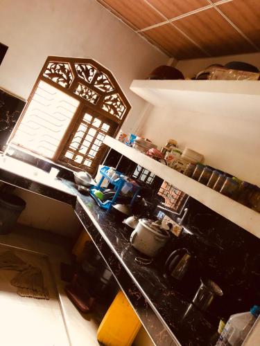 a kitchen with a counter top with a window at Nuwa'S Place Hostel in Sigiriya