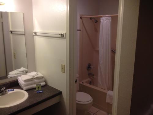 a bathroom with a sink and a toilet and a shower at American Dream Inn in Elk City
