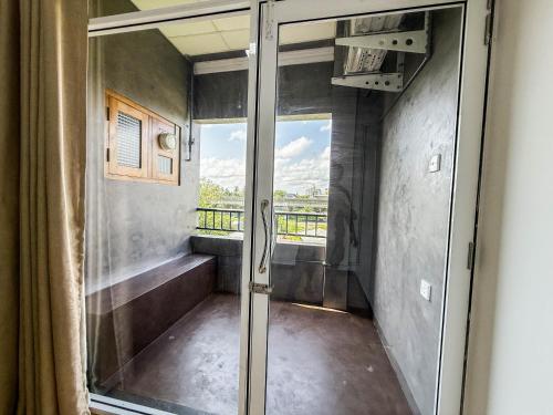 a room with a balcony with a sliding glass door at Gondolas Hotel Stay in Ragama