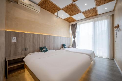 a large white bed in a room with a window at Zuolin Youli Xiaoying Exclusive Courtyard in Huairou