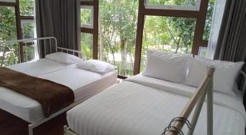 two beds in a bedroom with a window at VillaTel Salse in Bandung