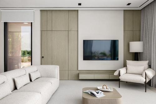 a living room with a white couch and a tv at Alrams Retreat in Ras al Khaimah