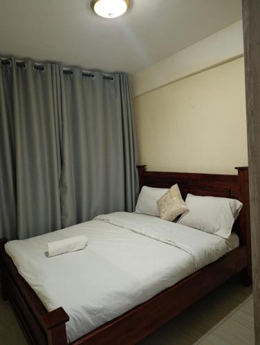 a bed with white sheets and pillows in a bedroom at Luxe one bedroom Kikuyu in Kikuyu