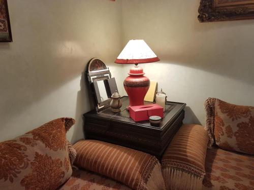 a table with a lamp and a mirror on it at Riad Dar Karima in Rabat