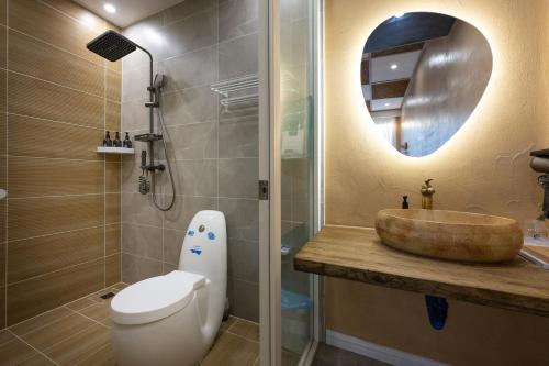 a bathroom with a sink and a toilet and a shower at Zuolin Youli Xiaoying Exclusive Courtyard in Huairou