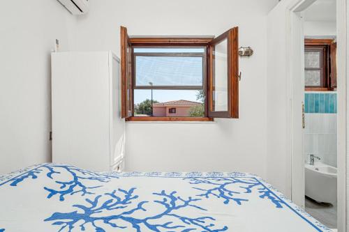 1 dormitorio con cama, ventana y lavamanos en Casa Ferdi, en San Teodoro