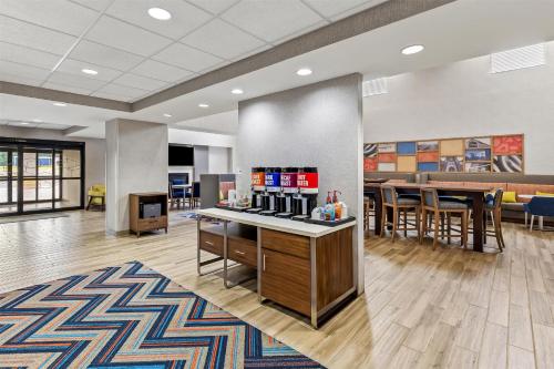 a lobby with a bar and tables and chairs at Hampton Inn & Suites Grove City in Grove City