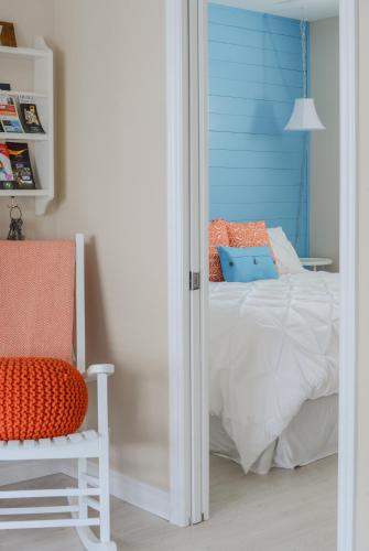 a bedroom with a bed and a chair and a window at The Village Suites in Wellington