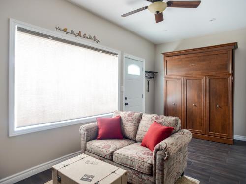 a living room with a couch with two red pillows at The Village Suites in Wellington
