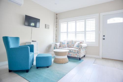 a living room with a couch and a chair at The Village Suites in Wellington