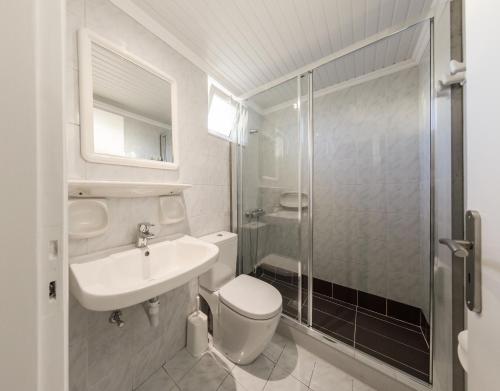 a bathroom with a toilet and a sink and a shower at Karras Livin in Laganas