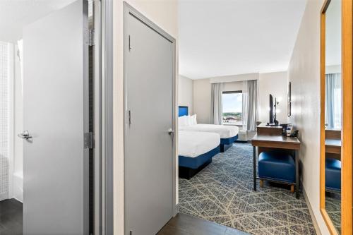 a hotel room with a bed and a desk and a bedroom at Hampton Inn Laramie in Laramie